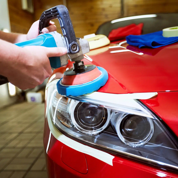 Person cleaning a car dashboard with a spray cleaner and yellow microfiber cloth